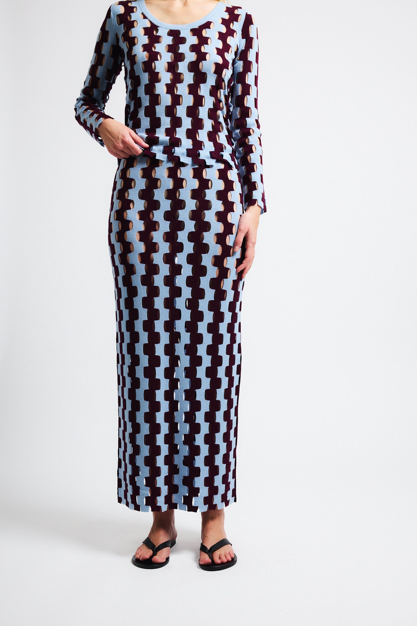 Link to "Rita" top. Image is of a female model wearing burgundy and baby blue zig-zag striped long sleeve scoop-neck shirt and long skirt. 