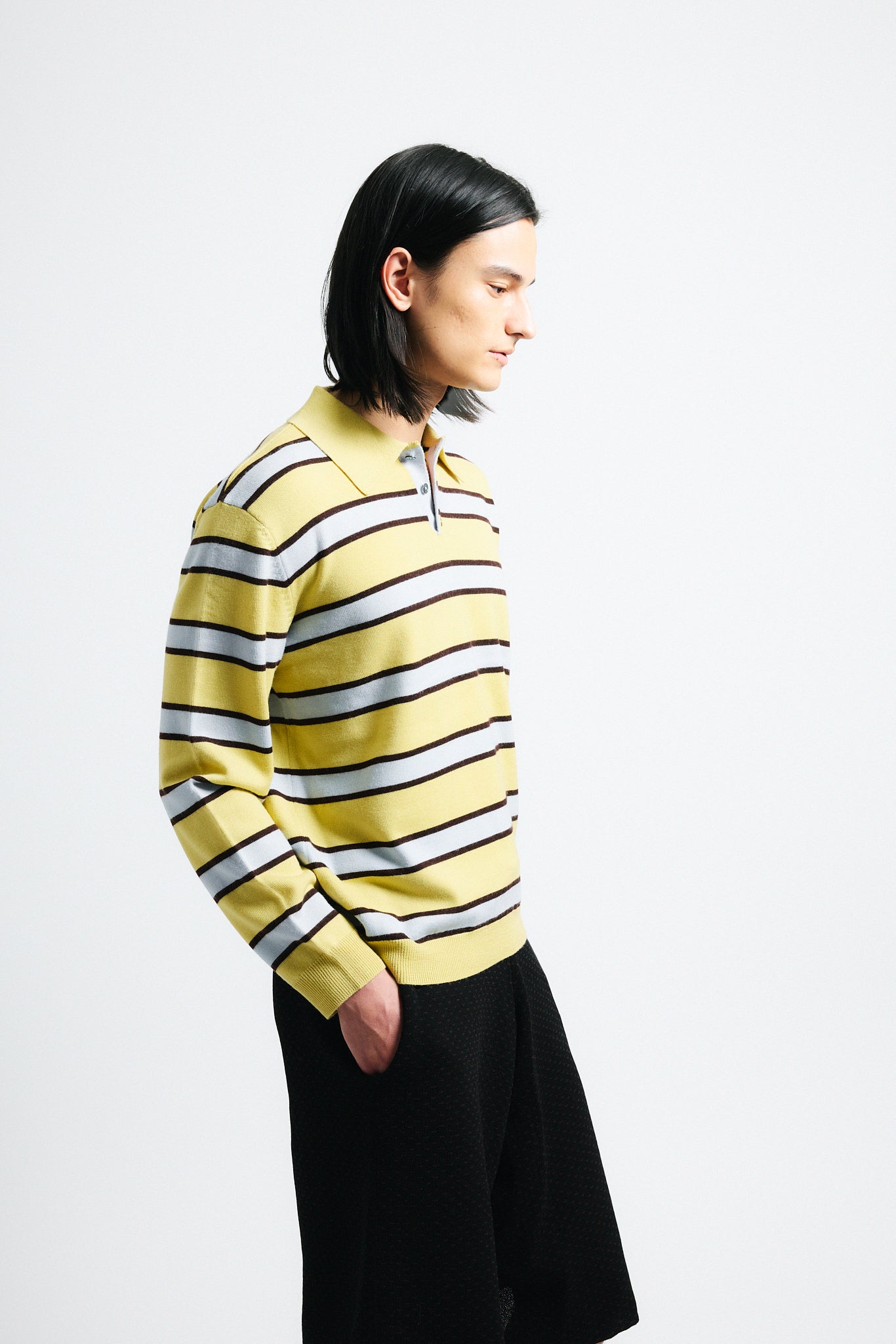 Link to "Ryan" sweater. Image is of a male model wearing yellow and grey striped polo with black shorts.