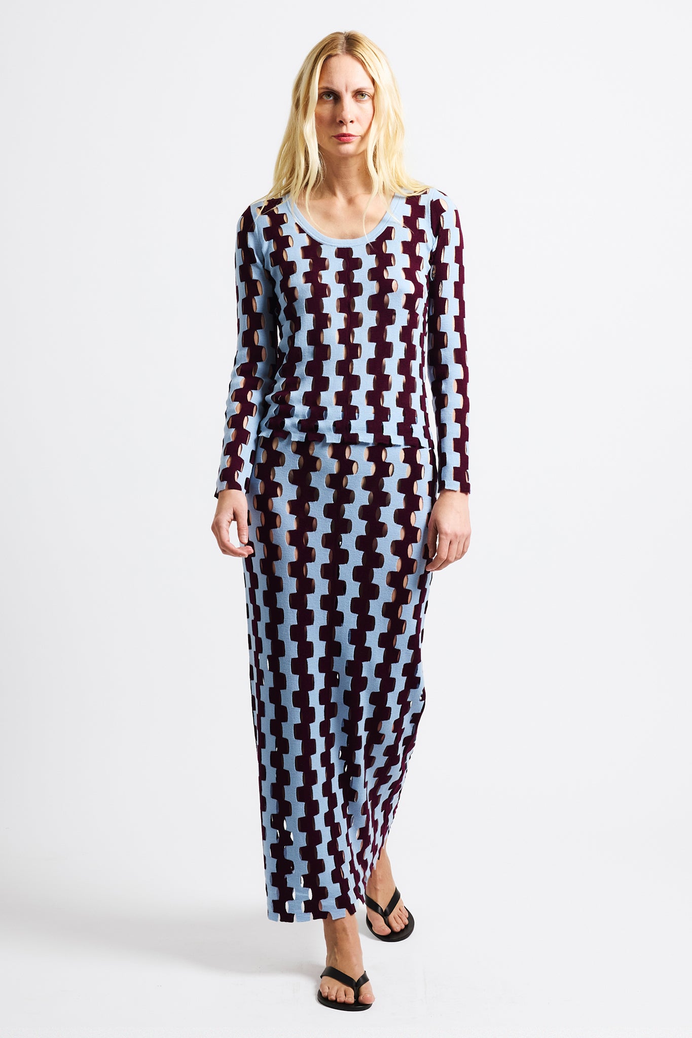 Link to "Rita" top. Image is of a female model wearing burgundy and baby blue zig-zag striped long sleeve scoop-neck shirt and long skirt. 