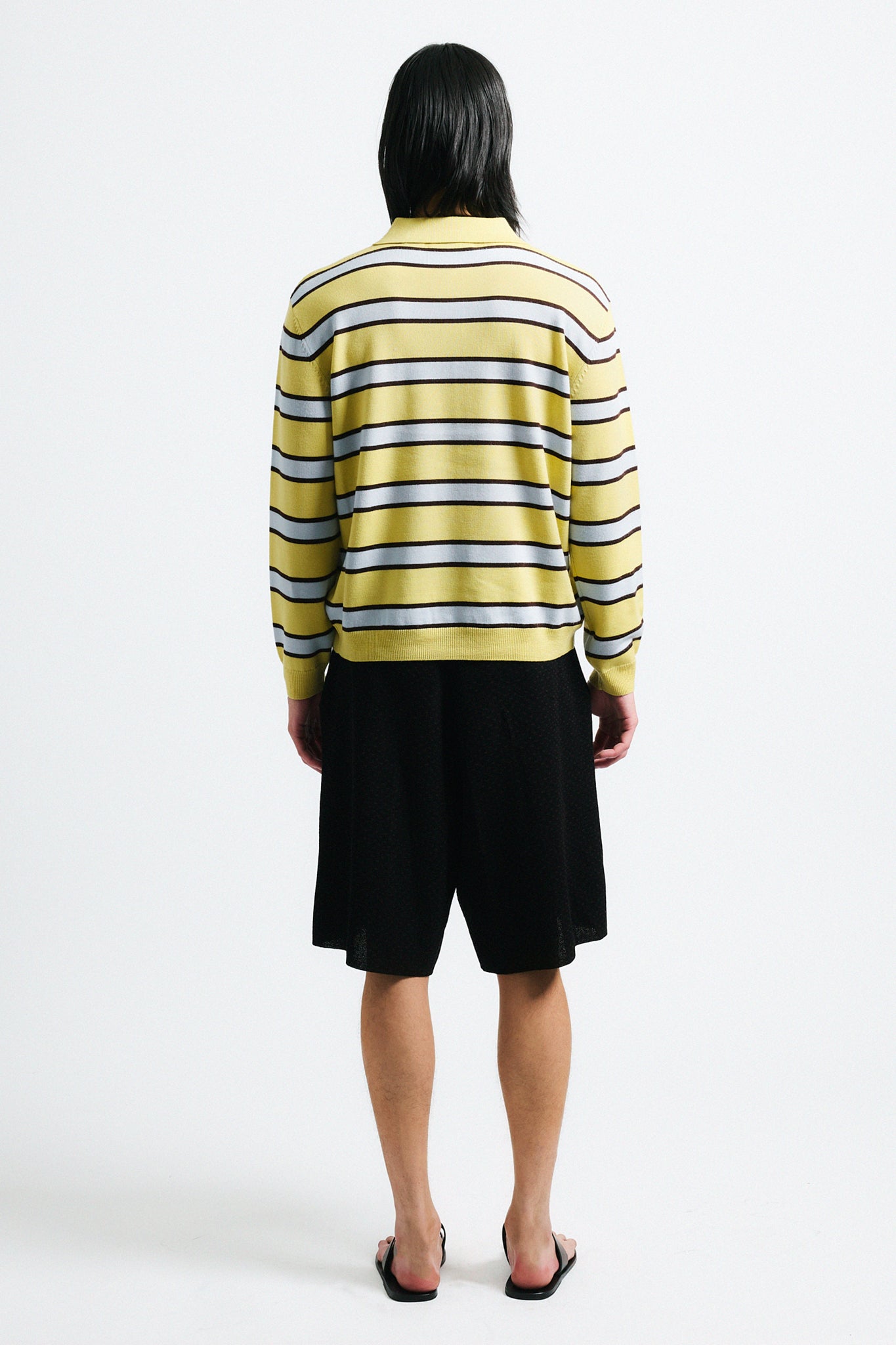 Link to "Ryan" sweater. Image is of a male model wearing yellow and grey striped polo with black shorts.